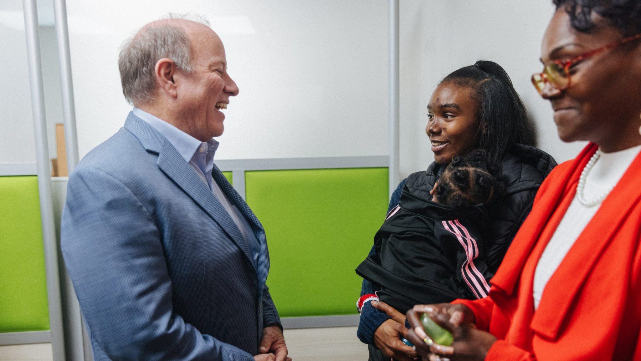 Detroit Mayor Mike Duggan speaks with a mom utilizing the city's Rides to Care service.