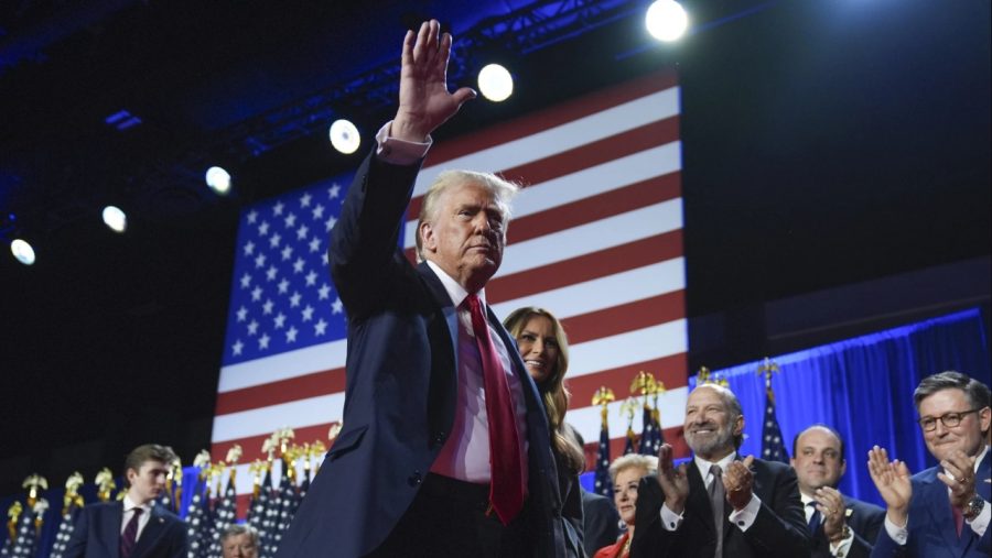 Republican presidential nominee former President Donald Trump waves as he walks with former first lady Melania Trump at an election night watch party at the Palm Beach Convention Center, Wednesday, Nov. 6, 2024, in West Palm Beach, Fla.