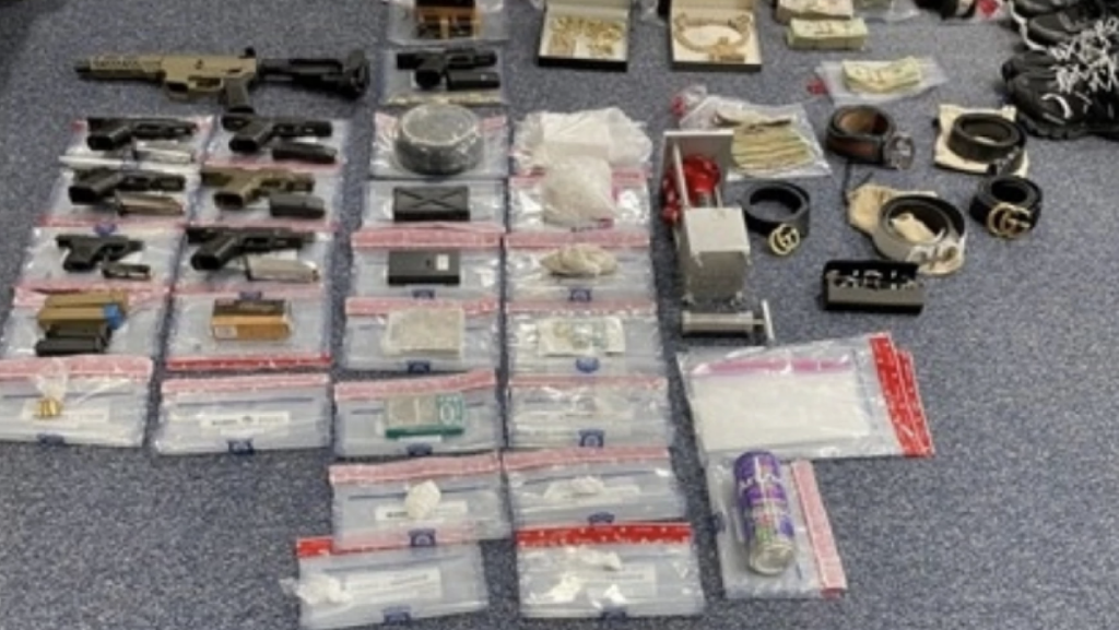 Guns, drugs, cash and jewelry seized by law enforcement.