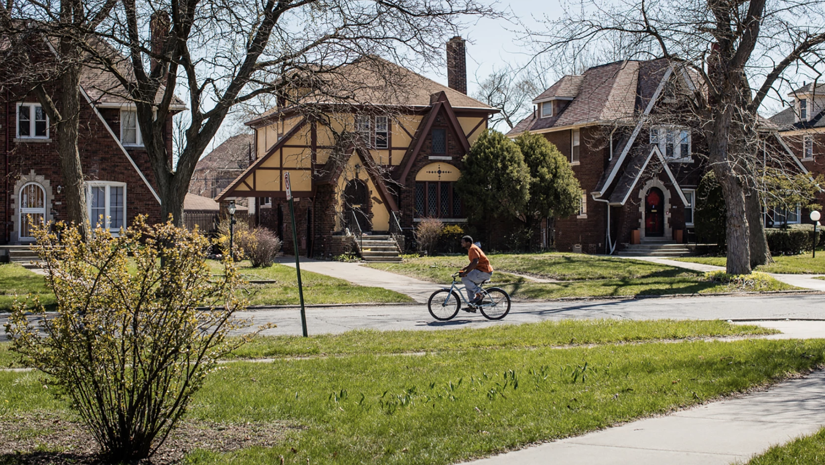 A man rides a bike in Detroit's Russell Woods neighborhood.