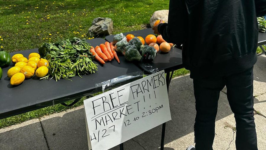 A table full of produce and a sign that reads "Free farmers market"