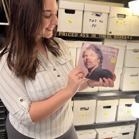 WDET's Madison Ganzak holding a 45 rpm record by Bob Seger & The Silver Bullet Band at Peoples Records in Detroit.