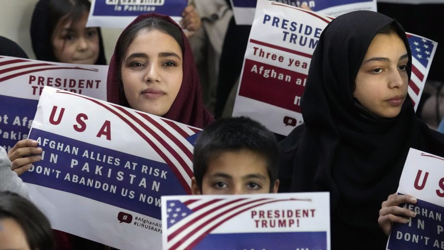 Afghan refugees hold placards during a meeting to discuss their situation after President Donald Trump paused U.S. refugee programs, in Islamabad, Pakistan, Friday, Jan. 24, 2025.