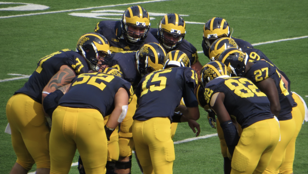 The University of Michigan football team huddles in a September 26, 2015, game against Brigham Young University.