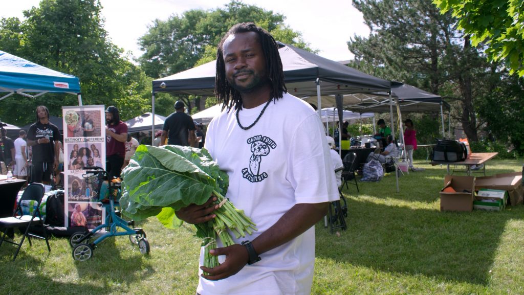 A man holding greens he picked up from the farmers market