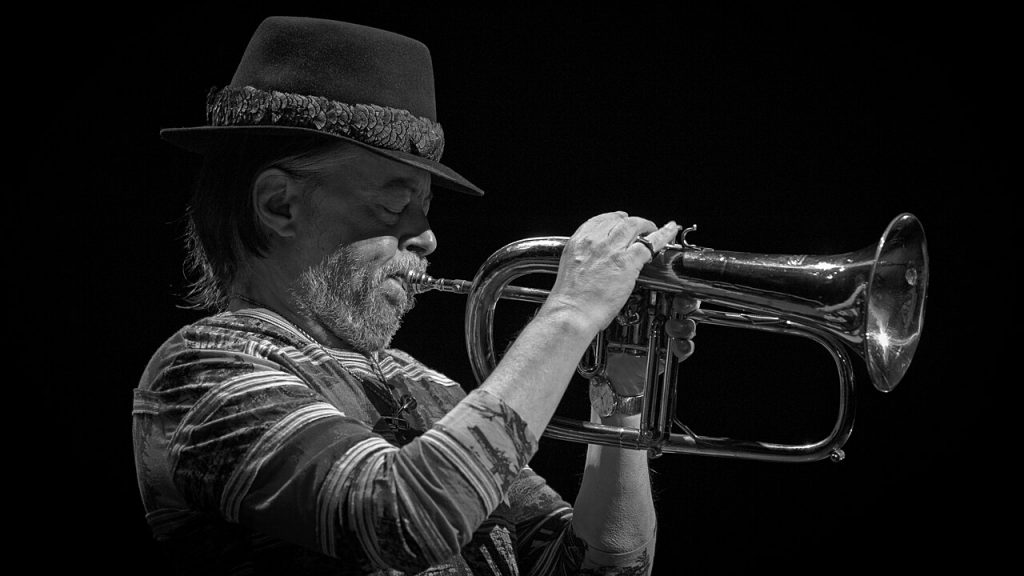 Black and white photo of Chuck Mangione playing his horn onstage
