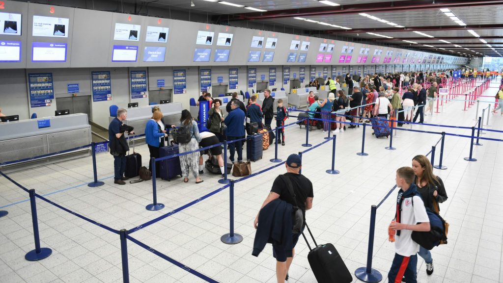 People wait in line at an airport security checkport