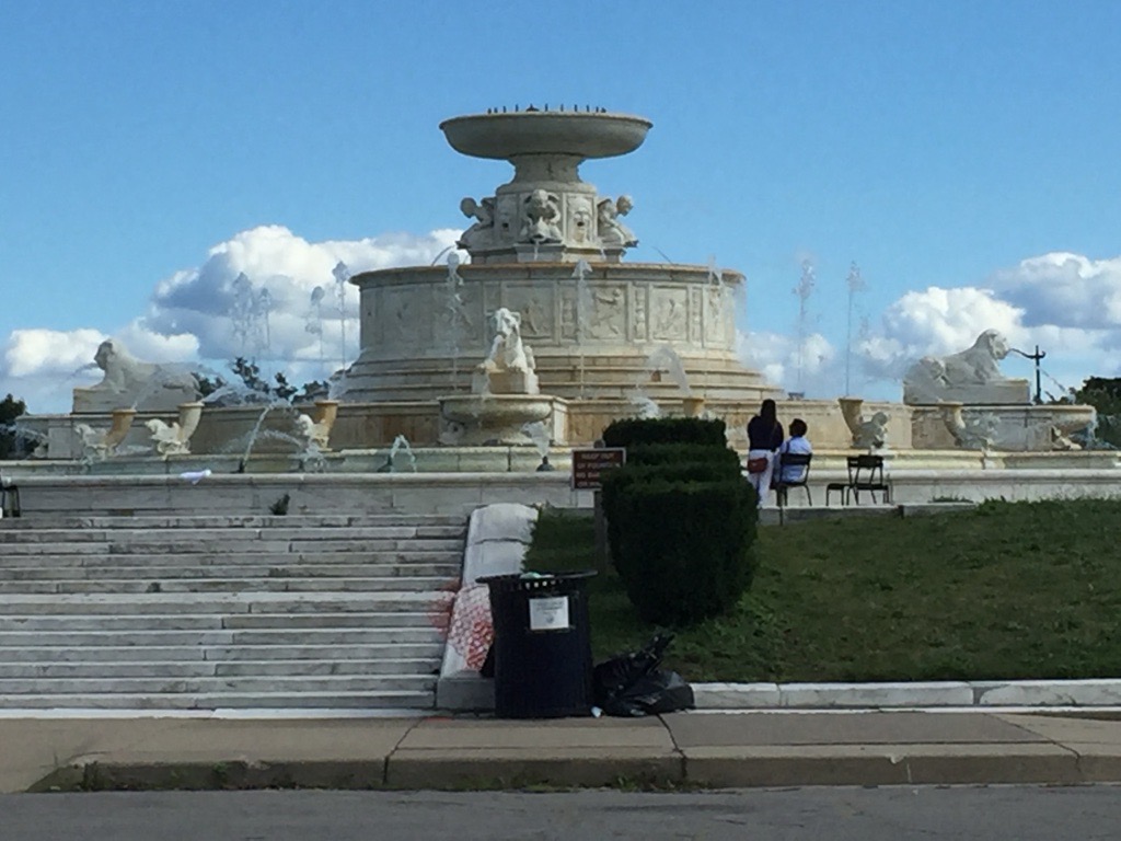 A trash can takes center frame with the stairs leading up to the James Scott Memorial Fountain on Belle Isle