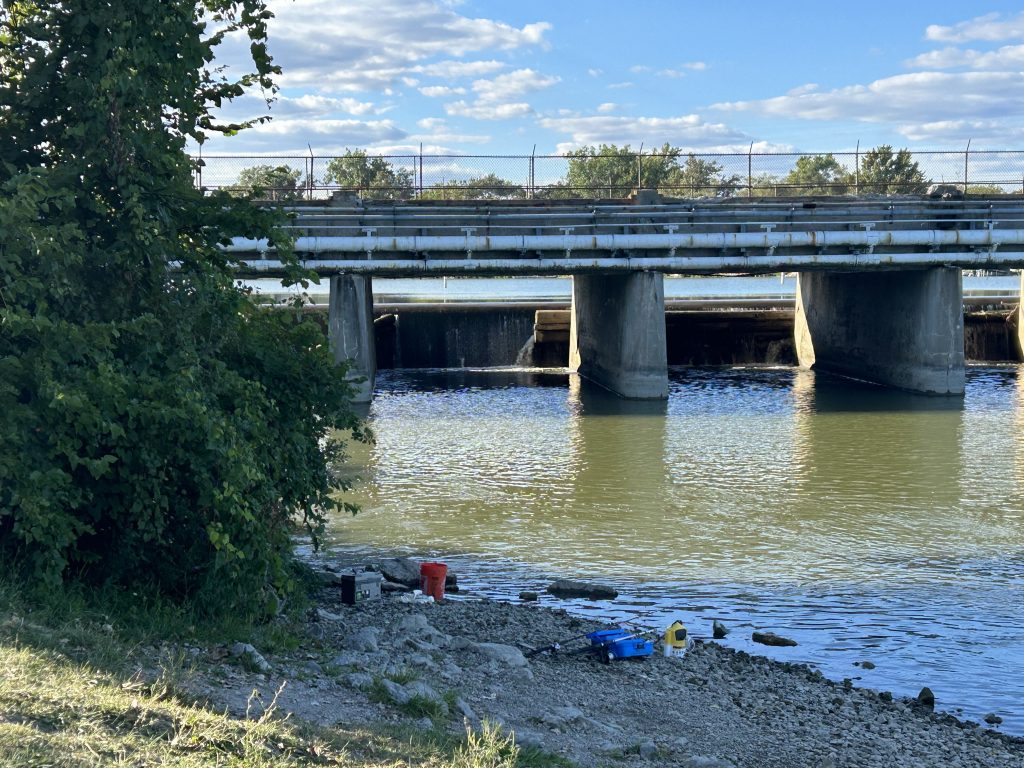 Flat Rock Dam. Fishing equipment strewn across the ground.