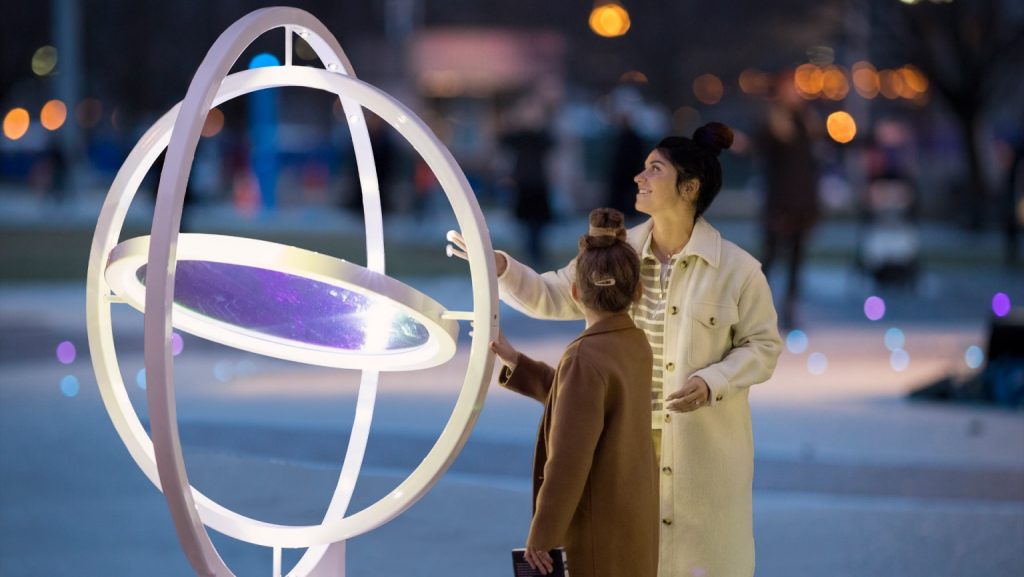Visitors spin a gyroscopic sculpture