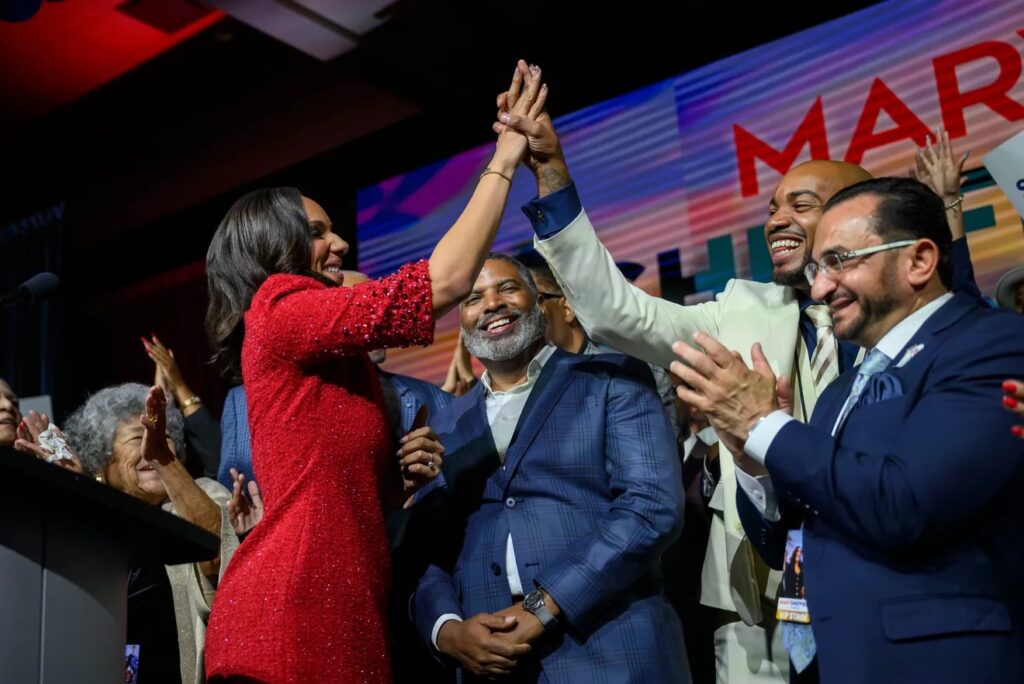 Mary Sheffield high fives in celebration as her victory in the 2025 mayoral election is announced.