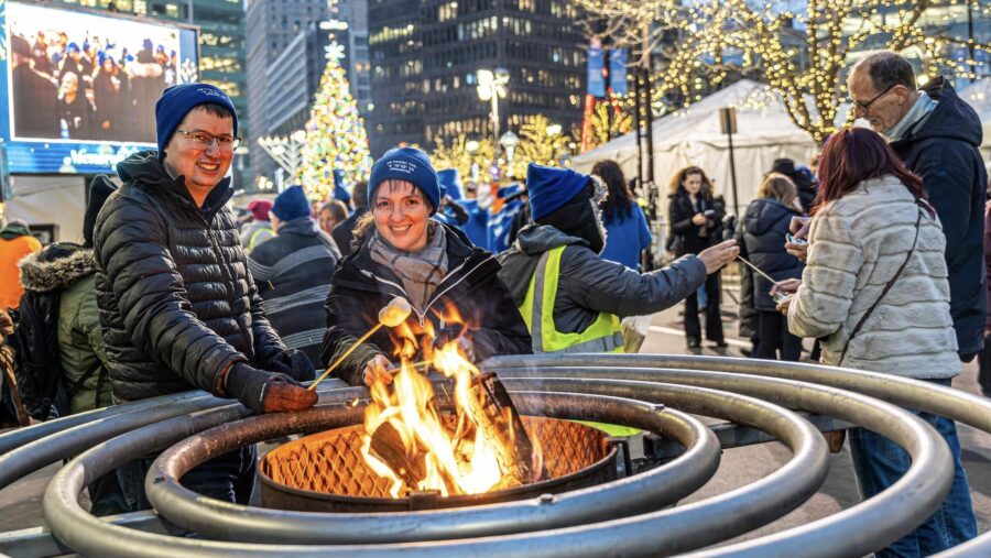 Two people roast marshmallows at Menorah in the D 2024