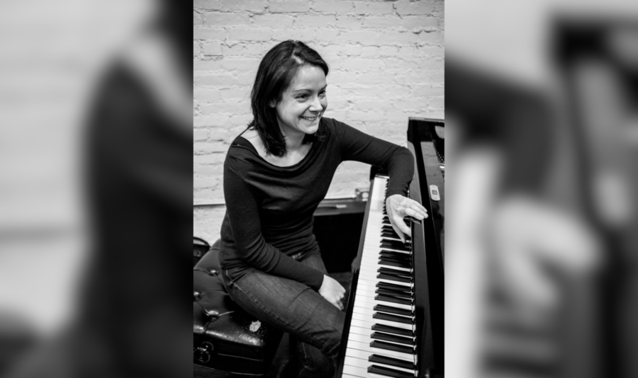 Kris Davis sits at the keys of a piano.